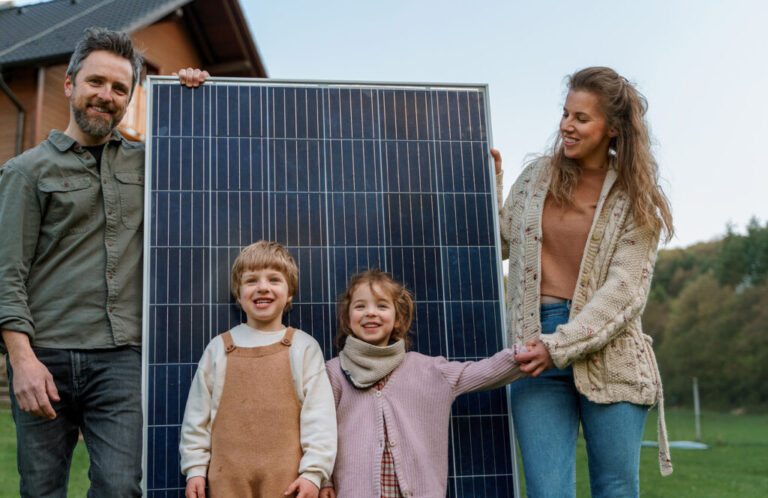 Happy family near their house with solar panels